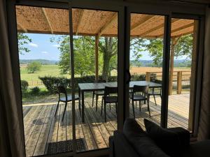 eine abgeschirmte Veranda mit einem Tisch und Stühlen in der Unterkunft Camping de Maillac in Sainte-Nathalène