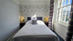 a bedroom with a bed in a room with a window at Stoke Lodge Hotel in Stoke Fleming