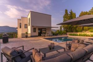 a villa with a swimming pool and a patio at Apartment Villa Dolce Vita Korcula in Lumbarda
