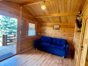 a blue couch sitting in the corner of a cabin at Domki u Haliny in Przewłoka