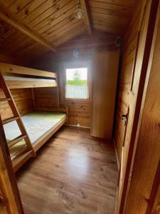 a small room with two bunk beds and a window at Domki u Haliny in Przewłoka