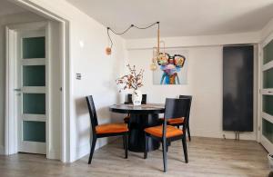 a dining room with a black table and chairs at Molly Marine - Bespoke 2 Bedroom Courtyard Apartment - 1 Minute From Brighton Pier in Brighton & Hove