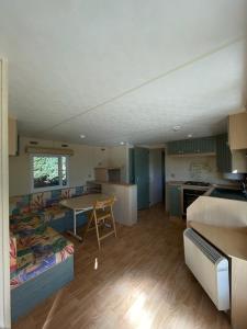 una camera con divano e tavolo di Mobil Home 40 4-6 personnes, nature, piscine parc du Pilat a Saint-Appolinard