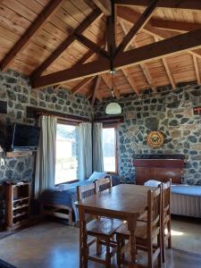 a living room with a wooden table and a bedroom at Cabañas Las Tahonas in Azul
