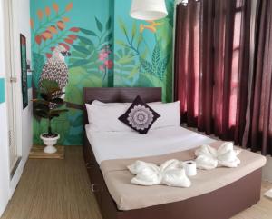 a bedroom with two beds with white towels on them at Napsule Suites in Davao City