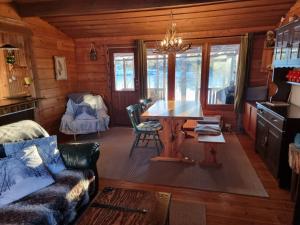 a living room with a table and a couch at Blockhaus am See in Arvidsjaur