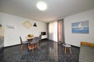 a living room with a table and chairs and a sailboat at Kaurinovic in Zaton