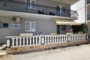a white building with a balcony with potted plants at Kaurinovic in Zaton