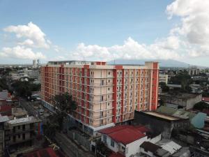 a large red and white building in a city at JK's Haven in Naga