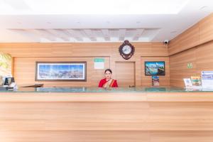 a woman is standing behind a counter in a waiting room at Moonlight Resort and Spa in Pokhara +52 photos