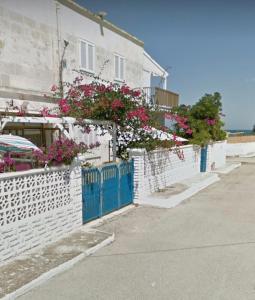 a house with a blue gate and pink flowers at Pietra & Mare Ostuni in Villanova di Ostuni