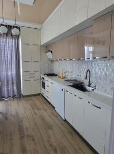 a kitchen with white cabinets and a sink at Magda's apartment in K'obulet'i