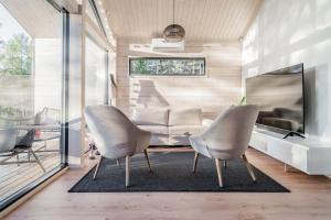 RaaseporiにあるYlellinen huvila meren rannalla Raaseporissaのリビングルーム(椅子2脚、ソファ付)