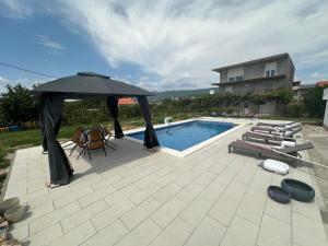 a patio with an umbrella and a swimming pool at TheSouth in Kraj