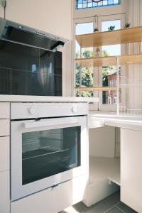 a white kitchen with a stove and a window at Kensington 1B1B with Sofa Double Bed Max 4 Guests in London