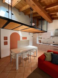明乔河畔的瓦雷奇奥La casa di Nina - Appartamenti Deluxe的厨房配有白色桌子和红色沙发
