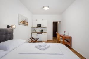 a bedroom with a bed and a table and a kitchen at APARTMENTS JADRANKa in Omišalj