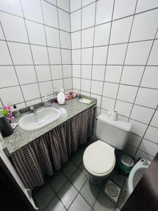 a bathroom with a toilet and a sink at Village prainha in Arraial do Cabo +14 photos