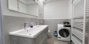 a bathroom with a sink and a washing machine at Elegant Apartments BOP in Portorož