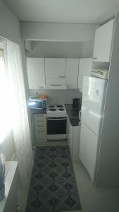 a small kitchen with a stove and a refrigerator at Apartment Rauha in Rovaniemi