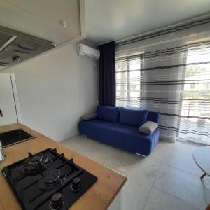 a kitchen with a stove and a blue couch at Weekender guesthouse 4 in K'obulet'i