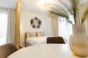 a bedroom with a bed and a vase on a table at Studio Vivo Residence in Baia Mare
