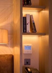 a book shelf with a clock and some books at Brook Lane Hotel in Kenmare