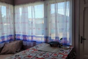 a bedroom with curtains and a bed with a table at Casa magallanica in Punta Arenas