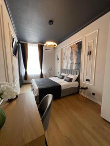 a bedroom with a large bed and a table at Euphoria Apartments in Beiuş