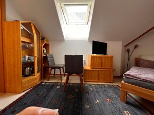 a living room with a bed and a tv at Haus Stegmeir in Hohenweiler