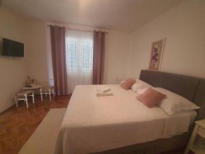 a bedroom with a large white bed and a window at Apartments Adrian in Bibinje
