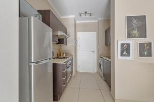 una cucina con frigorifero e fornello forno superiore di Modern Heritage Condo a Fourways