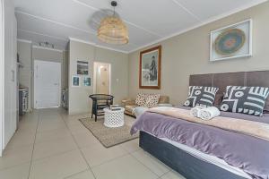 a bedroom with a bed and a living room at Modern Heritage Condo in Fourways