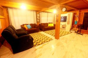 a living room with two couches and a television at Villa Lokon Tomohon in Tomohon