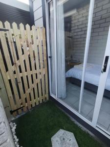 een balkon met een bed en een glazen schuifdeur bij Cozy Business overnighter in Bellville +1 foto