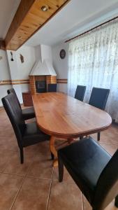 a dining room with a wooden table and chairs at Pensiunea Luminita in Bran