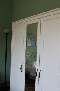 a white cabinet with a mirror in a bedroom at Garden House B&B in Striano