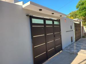 a garage with two brown doors on a building at 'Complejo Sol Andino" in San Fernando del Valle de Catamarca