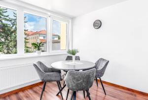 a table and chairs in a room with windows at MALŪNO Calm Getaway SELF CHECK-IN in Klaipėda +2 photos