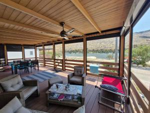 a screened in porch with a ceiling fan and a table at LuxMobil in Grebaštica