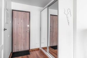 a hallway with sliding glass doors and wooden floors at MALŪNO Calm Getaway SELF CHECK-IN in Klaipėda