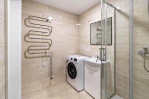 a bathroom with a washing machine and a shower at MALŪNO Calm Getaway SELF CHECK-IN in Klaipėda