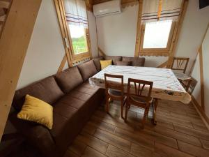 a living room with a couch and a table and chairs at Kućica naša bajka in Kupinovo
