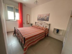 a bedroom with a bed with a red and white blanket at i 3 oliveti in Salignano