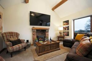 ein Wohnzimmer mit Couch und Kamin in der Unterkunft Rural Barn by Bham Nec with Games Room and Hot Tub in Allesley