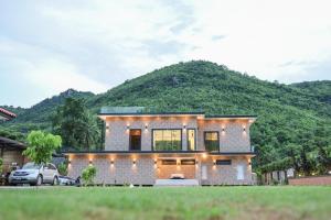 a house with a mountain in the background at Tiger House River Kwai ไทเกอร์เฮ้าส์ ริเวอร์แคว in Ban Tha Thong Mon +17 photos