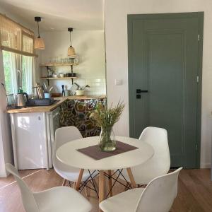 a kitchen with a table with chairs and a vase of flowers at Letnia Oficyna in Okoniny Polskie +24 photos