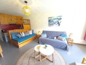 a living room with a couch and a table at Charmant Studio Le Lioran - Tour Sumène in Laveissière