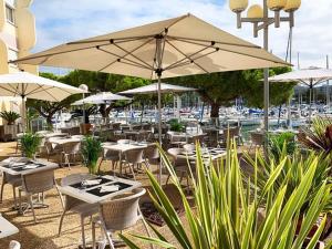 a restaurant with tables and chairs and umbrellas at Appart cosy Carnon-plage in Mauguio