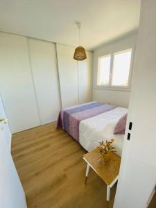 a small bedroom with a bed and a table at Appart cosy Carnon-plage in Mauguio